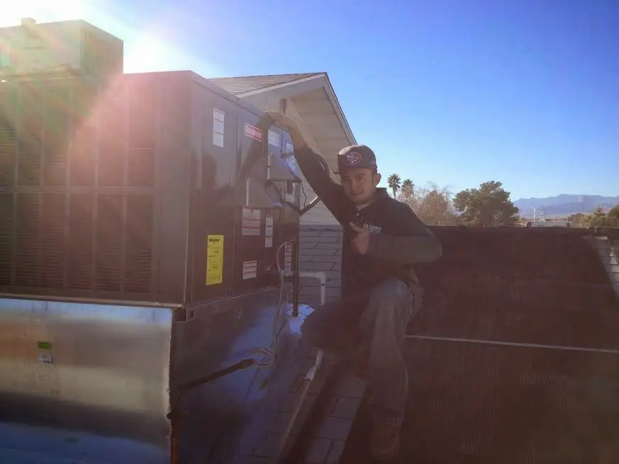 HVAC technician performing AC Tune-Up on a rooftop unit in East Goshen